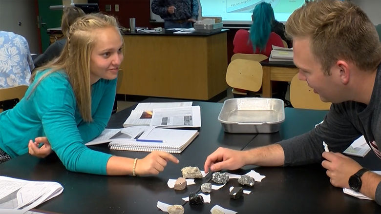 Two Environmental Science students at Penn State Behrend study rock samples in class.