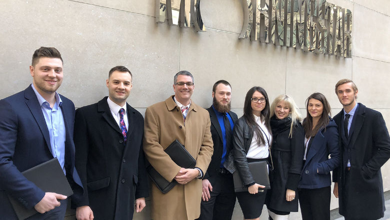 Eric Robbins is seen with students outside a building.