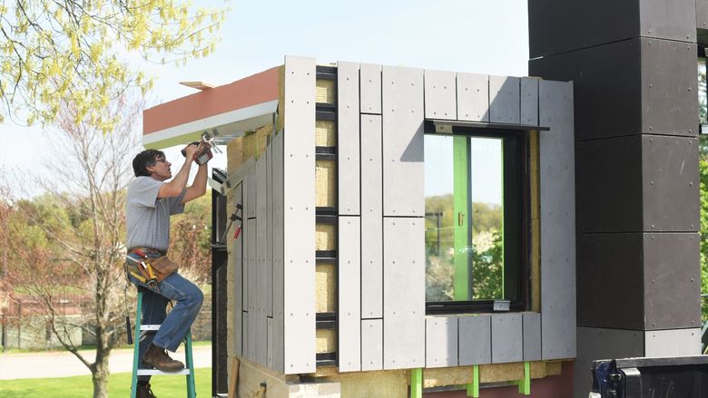 A contractor installs material on an architectural mockup at Penn State Behrend.