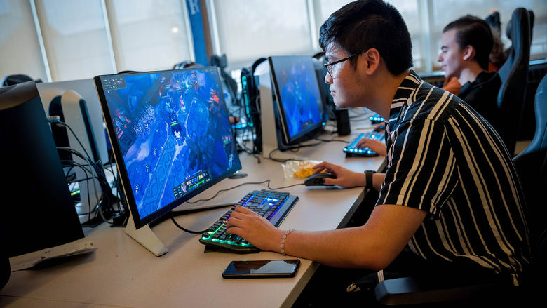 A male student plays a video game in Penn State Behrend's esports lounge.