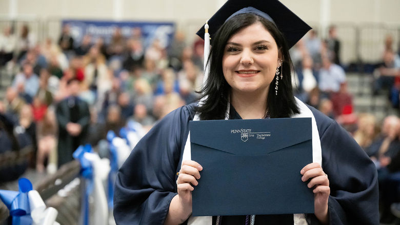 Penn State Behrend graduate Gabi Watson holds her diploma.