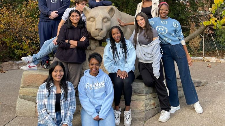 Ten students pose at Penn State's Nittany Lion shrine.