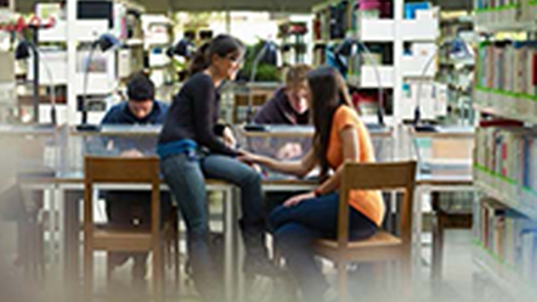 Men and women sitting at a table in a library