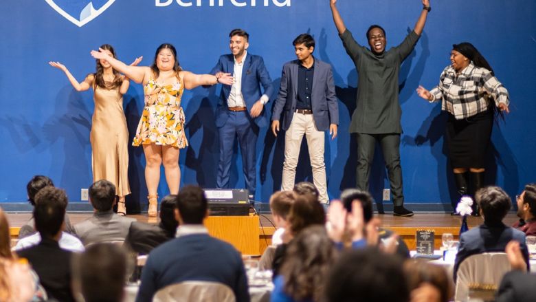 Students celebrate on stage at the Penn State Behrend Harambee Dinner.