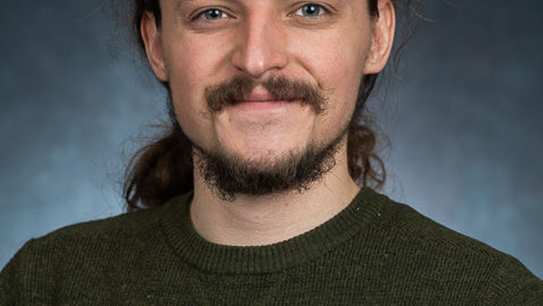 A headshot of Jasper Sachsenmeier wearing a black shirt.