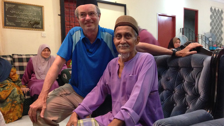 Penn State Behrend professor Jonathan Hall sits with his friend Wan Masa.