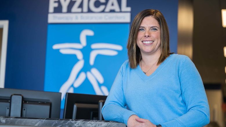 Penn State Behrend alumna Karla (Murray) Mazza leans on a counter at a physical therapy clinic.