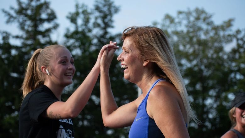 Two women high-five after the Run for Women at Penn State.