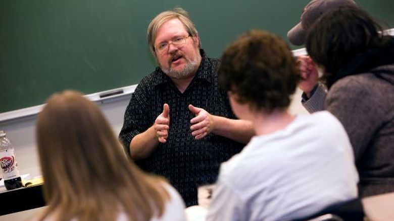 Penn State Behrend faculty member George Looney talks with students in a classroom.