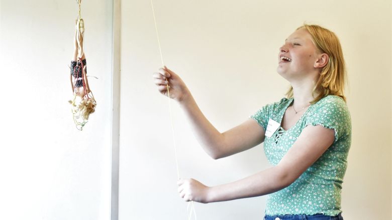 A female student drops a Barbie doll on a bungee cord at Penn State Behrend's Math Options Career Day.