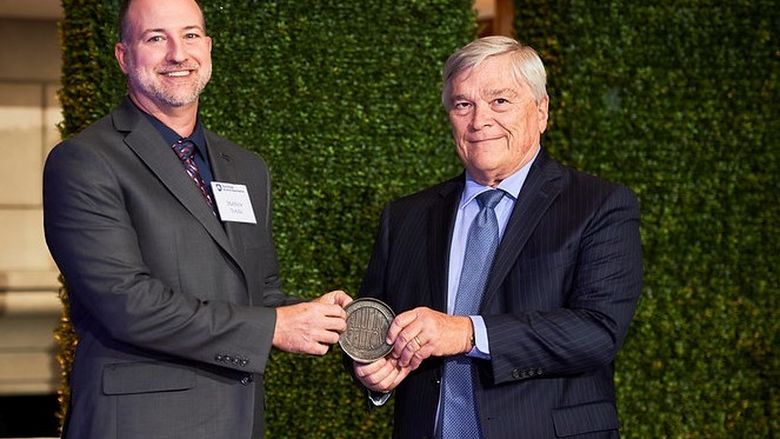 Penn State Behrend alumnus Matthew Totzke receives the Alumni Fellow award from Penn State President Eric Barron