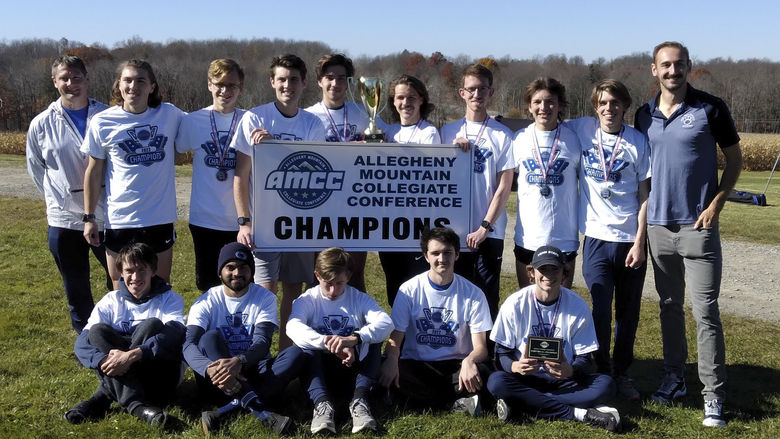 A group photo of the Penn State Behrend men's cross country team with an AMCC championship banner.