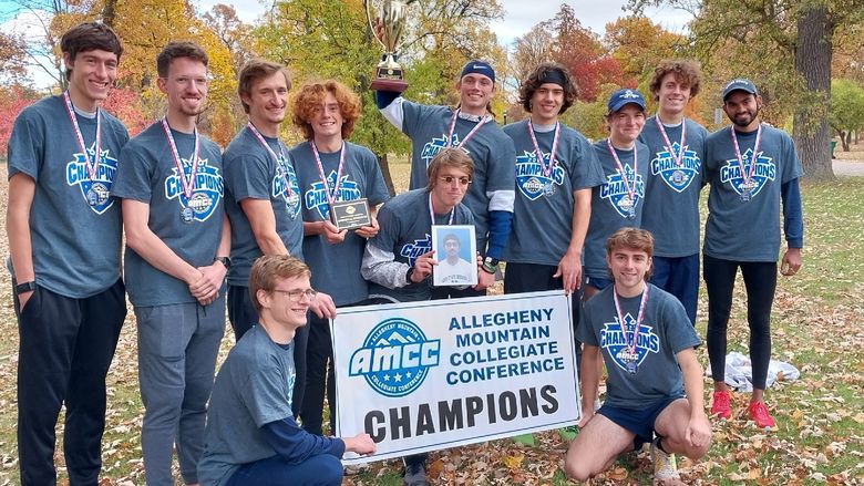 The Penn State Behrend men's cross country team poses with the AMCC championship banner.