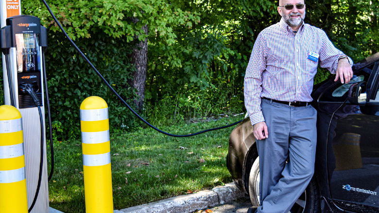 Penn State Behrend faculty member Michael Rutter charges an electric vehicle at a charging station on campus.