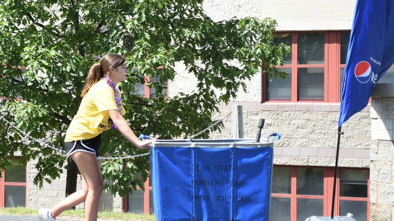 A female student pushes a luggage cart during Penn State Behrend's move-in day.