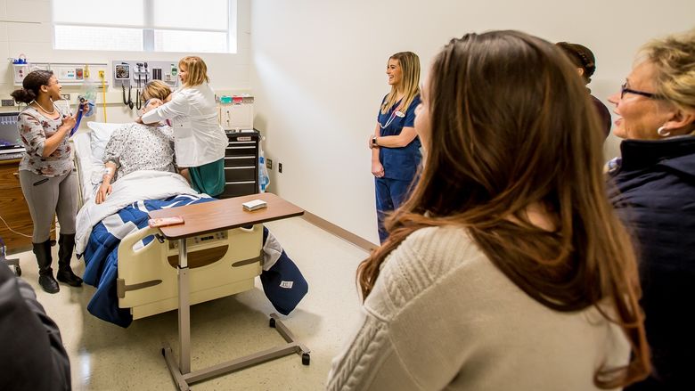Visitors test the mannequin in one of Penn State Behrend's new nursing simulation labs.