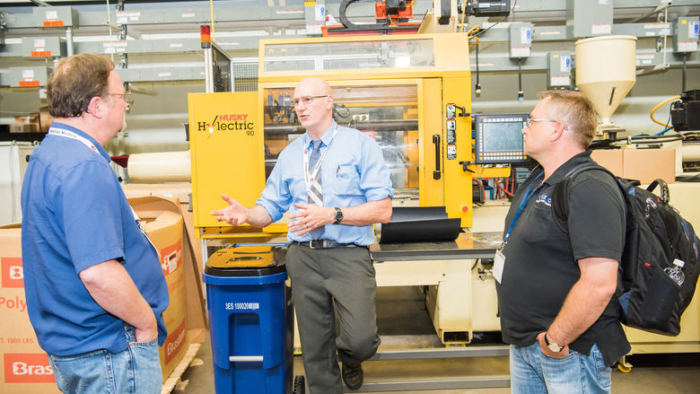 Brian Young, an associate professor of engineering, instructs two students during a Plastics Training Academy course.