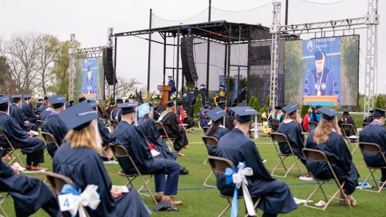 Graduates sit at an outdoor commencement ceremony at Penn State Behrend