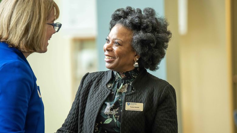 two women smiling and talking