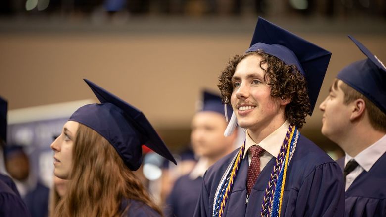 A graduate smiles during Penn State Behrend's spring commencement program.