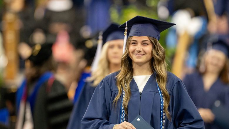 A graduate collects her diploma at Penn State Behrend's spring commencement program.