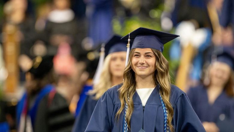 A Penn State Behrend graduate smiles after receiving her degree.