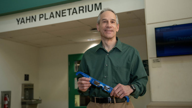 Planetarium director Jim Gavio holds a pair of eclipse glasses.
