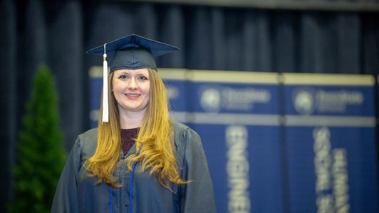 Brittany Anderson, a Penn State World Campus graduate who earned degrees in accounting and finance, poses before Penn State Behrend's December commencement program.