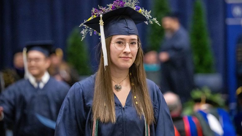 A new graduate walks back to her seat after receiving her degree at Penn State Behrend's fall 2022 commencement program.