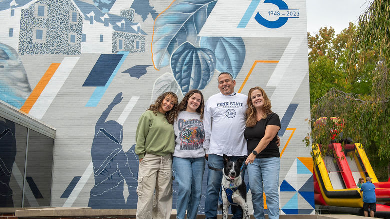 Guests pose in front of the new "Behrend Pride" mural at Penn State Behrend.