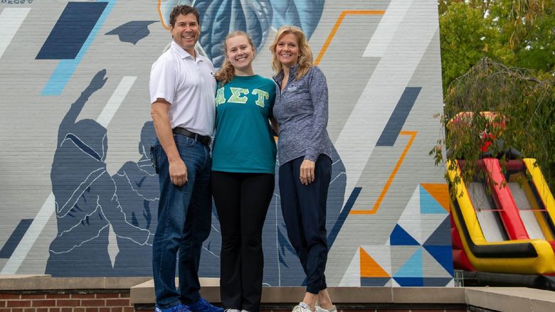 A student poses with her parents at Penn State Behrend's Parents, Families and Alumni Weekend.