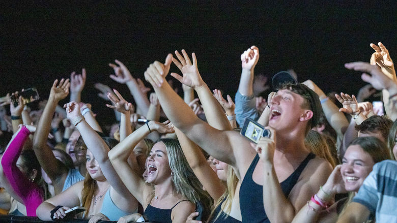 Students cheer in the front row of a Waka Flocka Flame concert at Penn State Behrend.