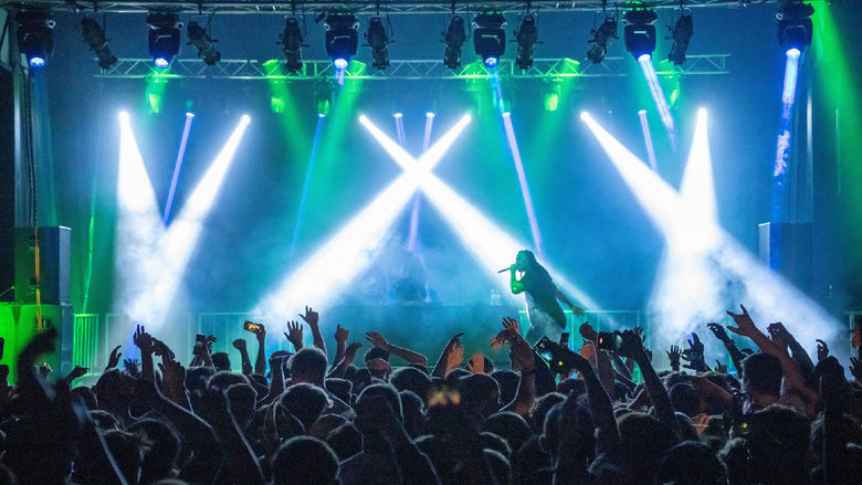Waka Flocka Flame performs under a spotlight at Penn State Behrend.