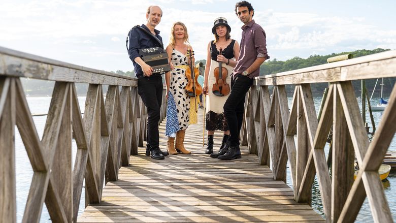 Publicity Photo: Reverie Road band members standing on a wooden bridge.
