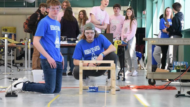 Two students watch as a model car is pushed down a test zone at Penn State Behrend's Science Olympiad.