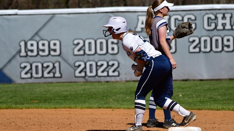 A Penn State Behrend softball player cheers while standing on base.