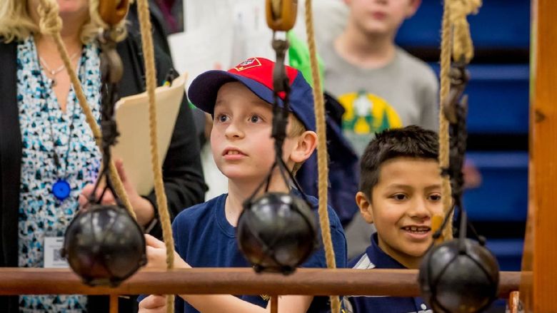 A boy experiments with pulleys at the Penn State Behrend STEAM Fair.