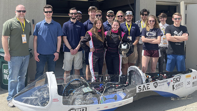 Students standing with a high-efficiency vehicle