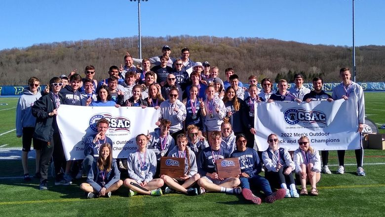 Penn State Behrend's track and field teams pose with the CSAC championship banners.