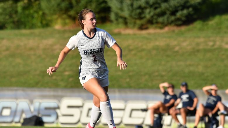 A Penn State Behrend female soccer player runs down the field toward the ball.
