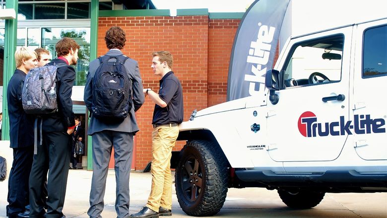 A corporate recruiter talks to several students at the Penn State Behrend career fair.