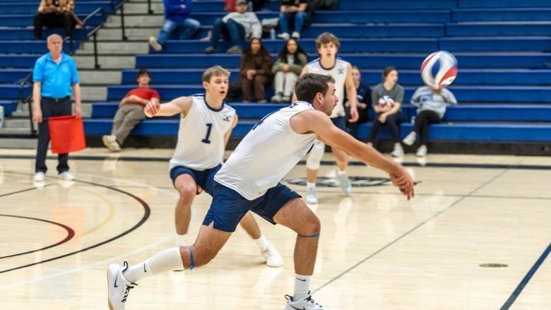 A Penn State Behrend volleyball player hits the ball with a dig.