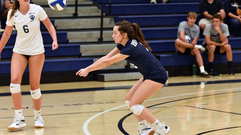 A Penn State Behrend women's volleyball player hits a dig.