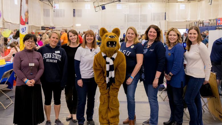 a group of women standing with the Nittany Lion mascot