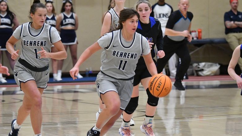 A Penn State Behrend female basketball player dribbles the ball upcourt.
