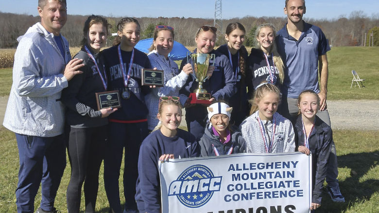 A group photo of the Penn State Behrend women's cross country team with an AMCC championship banner.