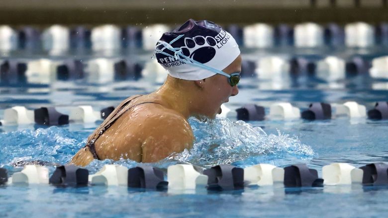 A female Penn State Behrend swimmer competes in a breaststroke race.