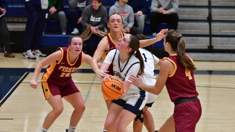 A Penn State Behrend basketball player prepares to shoot while being guarded by three opponents.