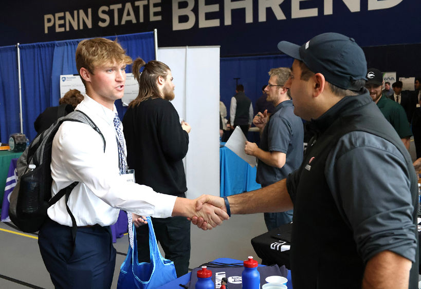 A Penn State Behrend student shakes a recruiter's hand during a career fair.