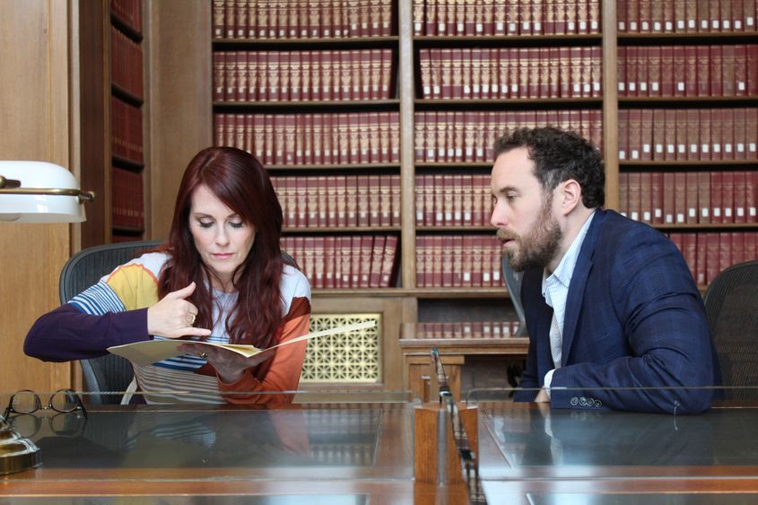 Two people work at a researcher's table at the National Archives in Washington, D.C.